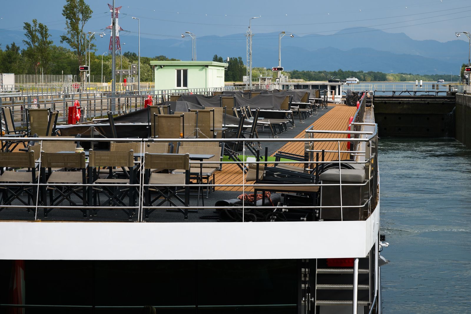 Sun deck of a river cruise ship with shaded seating as the ship waits in a lock