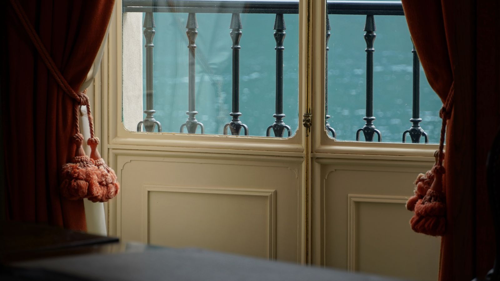 Tall glass doors opening to a railing over the water, like a river cruise French balcony