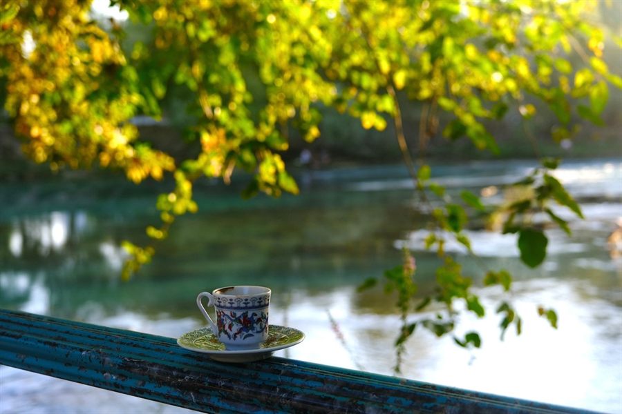 Coffee cup on a railing above a river